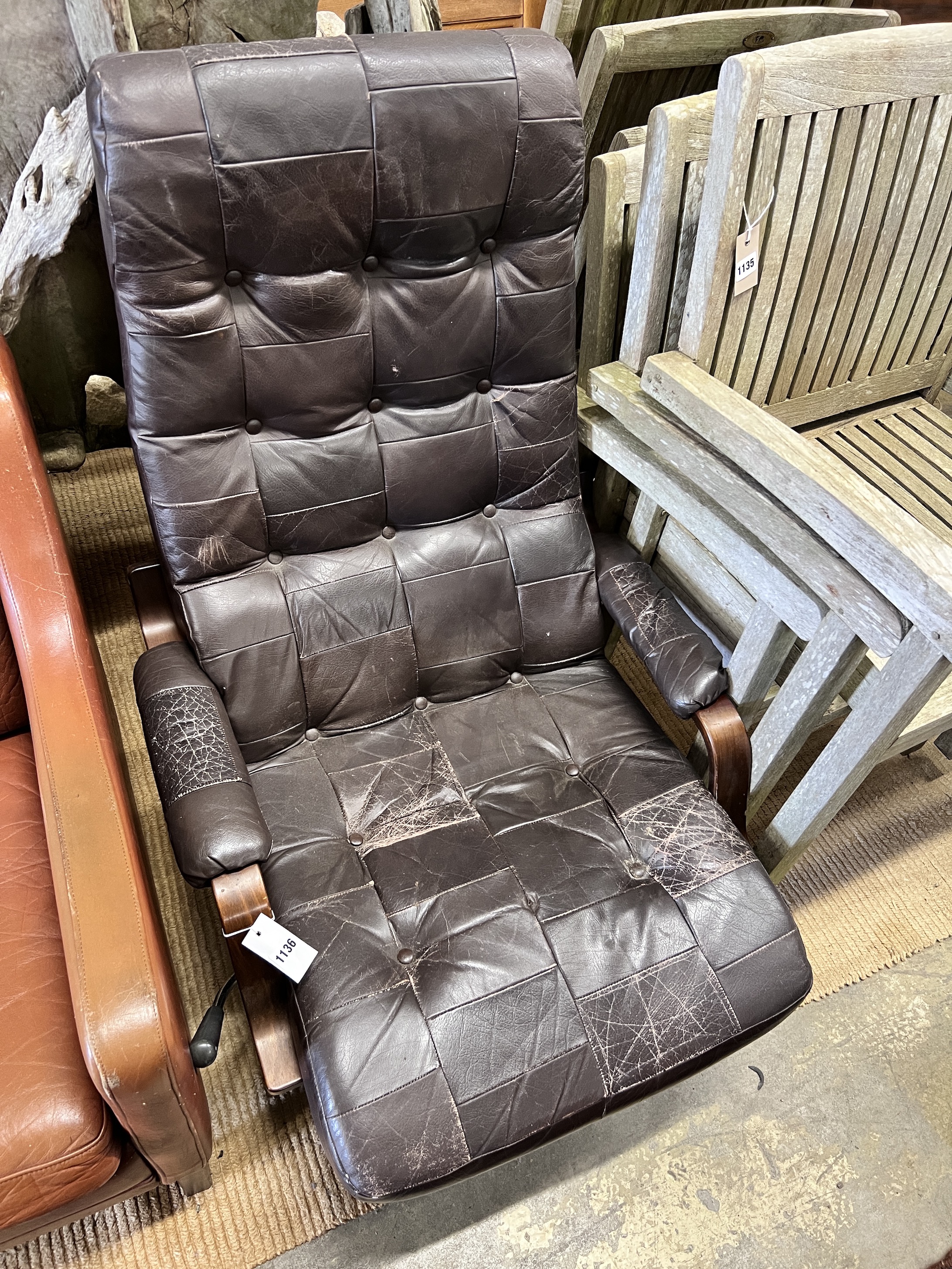 A Danish mid century leather upholstered swivel reclining armchair